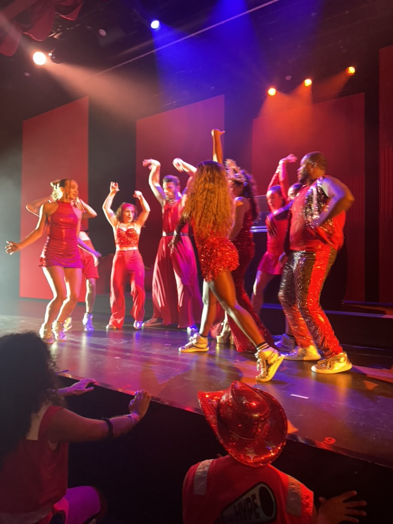 Onboard dance troupe mid-performance in red