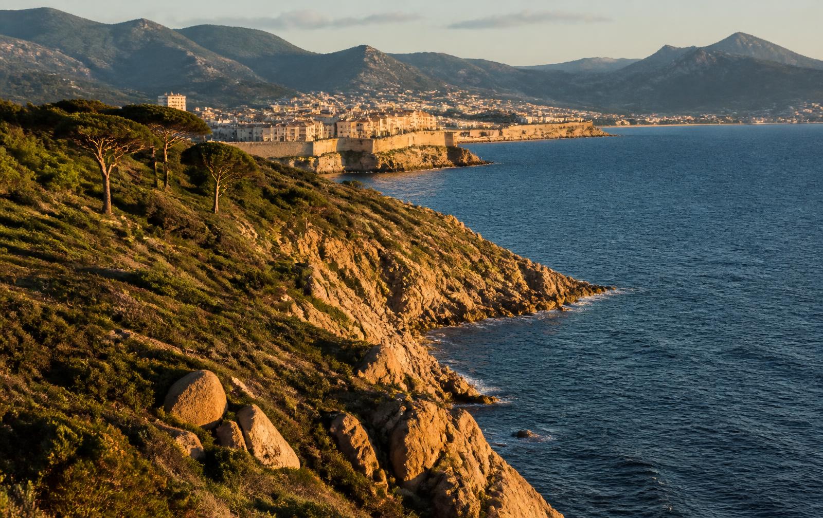 Ajaccio Corsica harbor with Napoleonic old town and mountain backdrop at sunset — French port on the 2026 Mediterranean Solar Eclipse Cruise