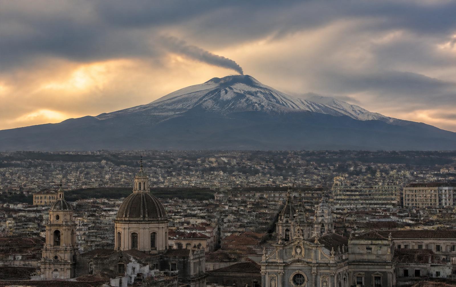 Mount Etna volcano rising above Catania under a moody pre-eclipse Sicilian sky — Sicilian port on the 2026 Mediterranean Solar Eclipse Cruise